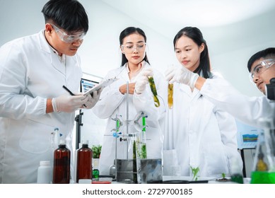 Team of scientists collaborating on algae and plant-based bioenergy research in laboratory, representing renewable energy testing clean technology innovation, sustainability, and ESG-focused corporate