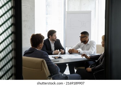 Team Of Serious Multiracial Businesspeople Negotiating, Solve Business, Search Solution, Seated At Desk Gathered In Modern Office Boardroom. Teamwork, Partnership, Formal Group Meeting Event Concept