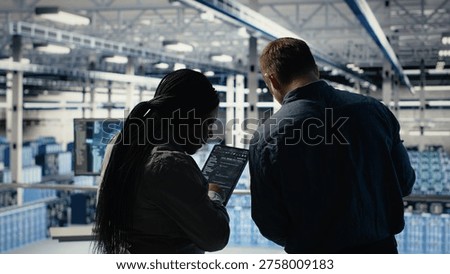 Team of server room technicians alerted by warning message on laptop causing infrastructure slowdowns. Teamworking data center colleagues see malfunction popup caused by software errors, camera B