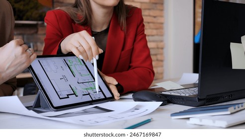 Team shows apartment layout to client on sleek tablet screen. Woman architect navigates through digital floor plan envisioning potential of transformed housen - Powered by Shutterstock