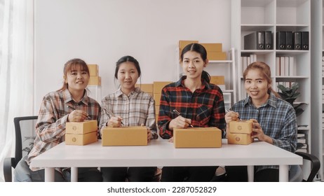 Team of smes warehouse checking email and writing on parcel cardboard box, Small business entrepreneur, SME, freelance online sellers, influencer and the team behind the work.