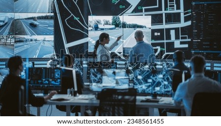 Team of Software Developers, Engineers and Data Scientists Working in a Modern Logistics Technology Company. Male and Female Having a Discussion in Front of a Screen with Surveillance CCTV Footage