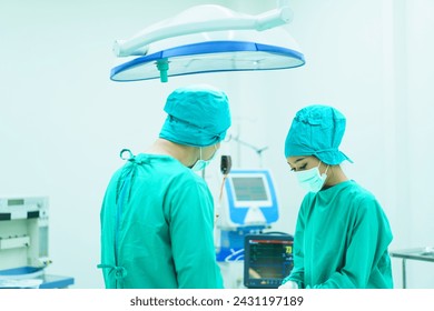 Team of specialist doctor making a handshake in operating room after successfully done on critical surgery. Doctors doing a handshake together after finished a surgery. Medical profession portrait. - Powered by Shutterstock