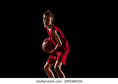 Team Spirit, Motivation. Portrait Of Boy, Basketball Player In Special Uniform Training Isolated Over Black Background. Concept Of Motivation, Sport, Action, Movement, Health. Copy Space For Ad