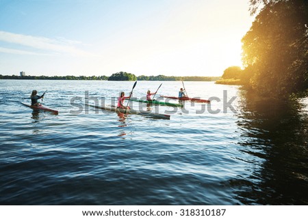 Team of sports kayaks racing on the lake