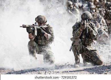 Team squad of special forces in action in the desert among the rocks covered by smoke screen