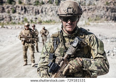 Team squad of special forces in action in the desert among the rocks