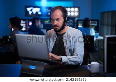 Team of stockbrokers are having a conversation in a dark office with display screens. Professional IT Technical Support Specialist Working on Computer Monitoring Server Data, Blockchain Network