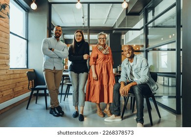 Team of successful businesspeople smiling at the camera in an office boardroom. Group of multicultural businesspeople working together in a modern workplace. - Powered by Shutterstock