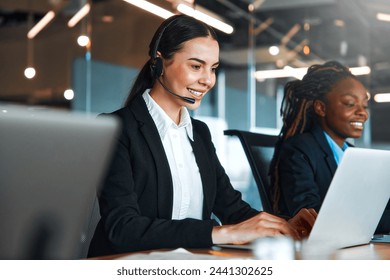 Team of successful call center employees with headsets sitting with laptops at the table and answering calls, providing assistance and support to customers in a modern office. - Powered by Shutterstock