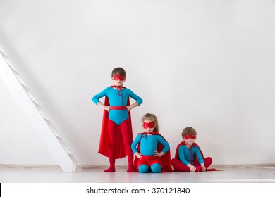 Team of superheroes. Kids heroes on white background at home.