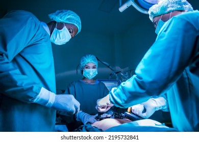 Team Of Surgeon Doctor Using Defibrillator To Give Electrical Shock To Patient Heart Who Is Suffering From Cardiac Arrest In Emergency Surgical Room For Healthcare