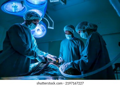 Team Of Surgeon Doctor Using Defibrillator To Give Electrical Shock To Patient Heart Who Is Suffering From Cardiac Arrest In Emergency Surgical Room For Healthcare (selective Focus On Middle Man)