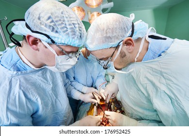 Team Of Surgeon In Uniform Perform Heart Transplantation Operation On A Patient At Cardiac Surgery Clinic