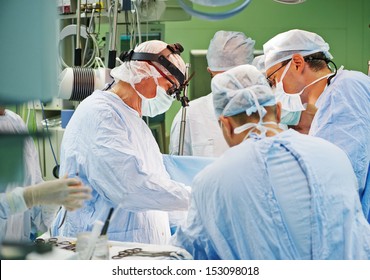 Team Of Surgeon In Uniform Perform Operation On A Patient At Cardiac Surgery Clinic