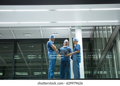 Team of surgeons discussing x-ray in corridor of hospital. Healthcare workers in the Coronavirus Covid19 pandemic
