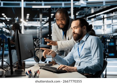 Team of system administrators using computer in server farm, analyzing data. Data center office colleagues doing brainstorming, examining equipment, ensuring system integrity and security