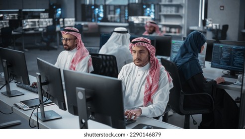 Team of Talented Young Middle Eastern Professionals Working in a Technological Research and Development Agency. Computer Screens with Software Code and Technical Neural Network Diagrams