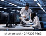 Team of technicians doing maintenance on server hub to optimize it for data processing requirements of artificial intelligence workloads. Teamworking employees inspecting neural network data center