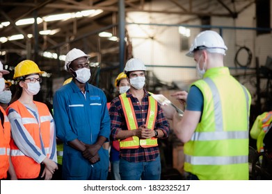 A team of technicians, foreman and engineers Accepting assignments from a manager or supervisor In the morning meeting before work In which everyone wear surgical masks to prevent the coronavirus - Shutterstock ID 1832325217