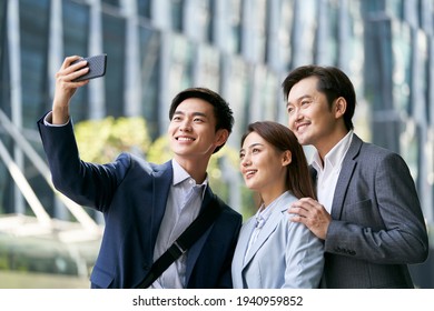 Team Of Three Asian Businesspeople Taking A Selfie In Downtown Financial District Of Modern City