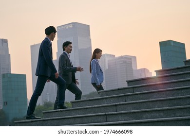 team of three asian corporate executives walking in downtown financial district - Shutterstock ID 1974666098