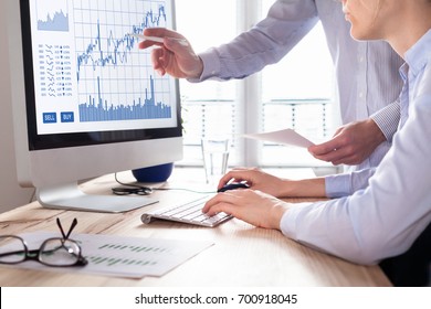 Team of traders working with forex (foreign exchange) trading charts and graphs on computer screen, concept about stock market investment, finance, selling and buying
