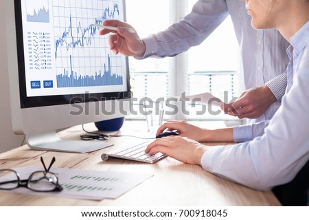 Team of traders working with forex (foreign exchange) trading charts and graphs on computer screen, concept about stock market investment, finance, selling and buying