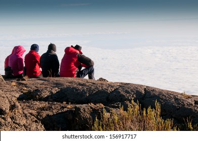 A Team Of Trekkers Gazing Over The Early Morning Clouds On The Trek To Kilimanjaro Summit