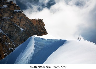 Team Of Two Alpinists Climbing A Mountain