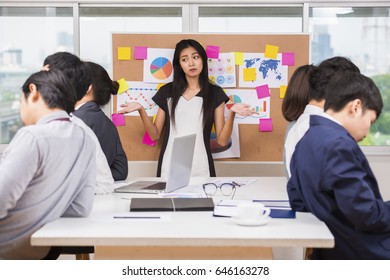 Team Of Unhappy Asian Businesspeople Sitting In Business Meeting. Selective Focus
