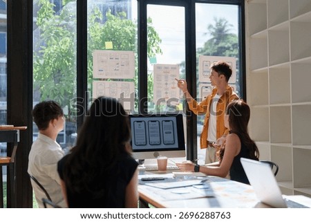 Team of ux designers collaborating, developing user experience and mobile application interface wireframes in a modern office space