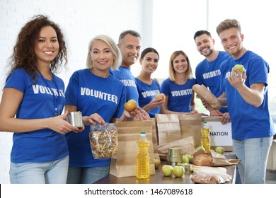 Team Of Volunteers Collecting Food Donations Indoors