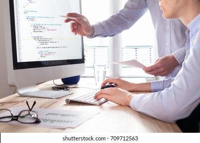 Team Of Web App Developers Coding Website Source Code And Debugging On Computer Screen Before Deployment