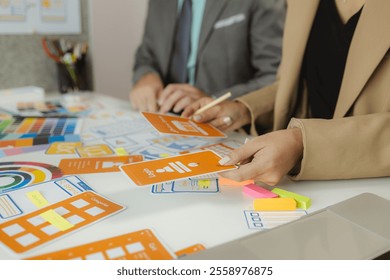 A team of web developers discusses how to best organize a website layout. They share ideas on how to best optimize a digital product, ux ui team is working together in the office