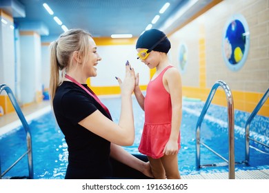 Team woman coach and kid athlete in pool, swimming training school for children. - Powered by Shutterstock