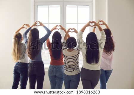 Team of women standing together by window and doing heart shaped sign hand gesture. Group of six young ladies willing to make world better place. Love, harmony, gratitude, support, solidarity concept Stock photo © 