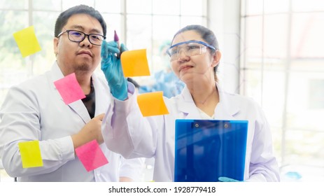 Team Work Asia Woman And Man Scientists Analyzing Study Data And Evaluating Microscope Success For Work Shop. Health Care Researchers Doing Research Testing I Life Science Laboratory