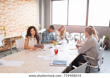 Team at work concept. Group of young business people in smart casual wear working together in creative office.