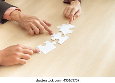 Team work concept, Hands hold puzzles on wood table