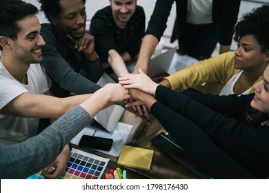 Team Of Work Of Creative Designers Showing Unity With Their Hand Together During Meeting. Business And Team Work Concept.