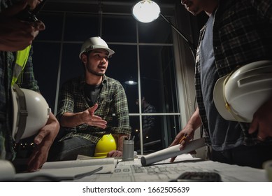 Team Work, Engineers discussion with Construction team and Architects in meeting room at night, Working overtime, Compulsory overtime. - Shutterstock ID 1662505639