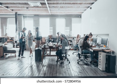 Team at work. Group of young business people in smart casual wear working together in creative office - Shutterstock ID 572804956