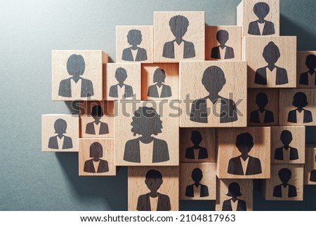 Team work and human resource management concept. Top view of various wood cubes with people icons.
