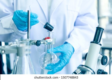 Team Work Scientists Analyzing Study Data And Evaluating Microscope Success For Work Shop. Health Care Researchers Doing Some Research With Dropper Chemical Testing In Life Science Laboratory.