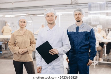 Team workers operators man and woman background food products conveyor with wheat flour. Crew of electrical mill machinery for production. - Powered by Shutterstock