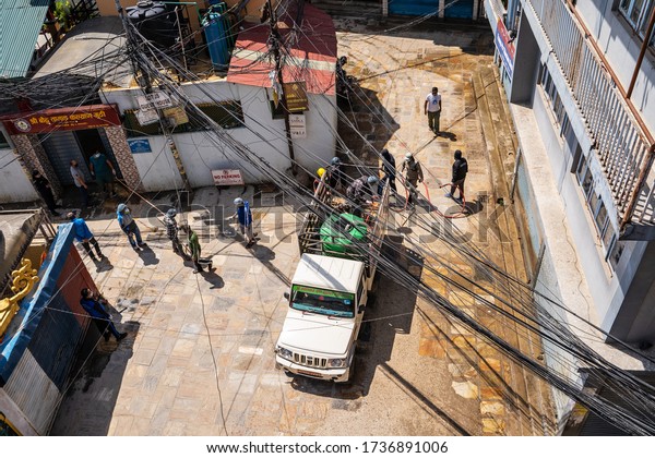 A team of workers spraying houses walls,\
sidewalks with a disinfectant chlorine compound in an attempt to\
counter the spread of coronavirus infection. Nepal, Kathmandu,\
Boudha district. April 1,\
2020.