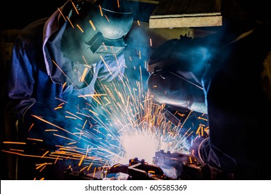 Team workers are welding automotive part in car factory