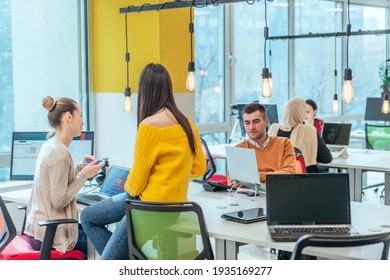 Team Working On A Digital Project. Group Of Coworkers Working In A Startup Business Environment. Employees Having Fun In A Modern Office.