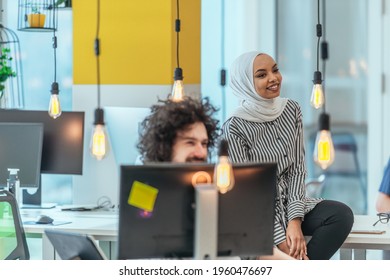 Team Working On A Digital Project. Group Of Coworkers Working In A Startup Business Environment. Employees Having Fun In A Modern Office.